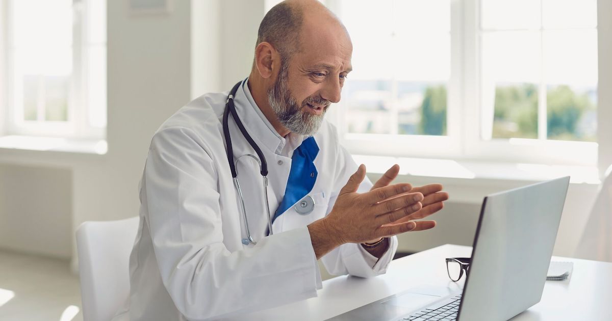 Doctor sitting at a desk looking at a computer