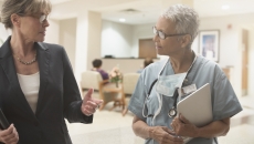 Two people in a clinical setting walking together Two people in a clinical setting walking together