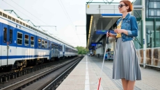 Blind person standing at a train station Blind person standing at a train station