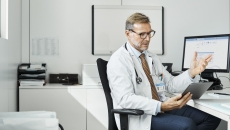 Healthcare practitioners consulting with person on mobile device Healthcare practitioners consulting with person on mobile device