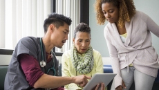 Healthcare professional two people looking at data on a tablet Healthcare professional two people looking at data on a tablet