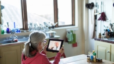 person holding tablet sitting at table person holding tablet sitting at table