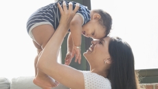 Person holding another smaller person above their head Person holding another smaller person above their head