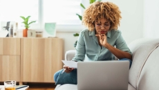 Individual sitting on a couch and looking at a computer Individual sitting on a couch and looking at a computer
