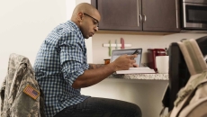 Person sitting at a desk looking at a laptop Person sitting at a desk looking at a laptop