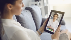 Person interacting with a healthcare professional via tablet Person interacting with a healthcare professional via tablet