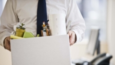 A worker holding a box of belongings. A worker holding a box of belongings.