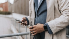 Midsection of a person in a suite wearing two rings and looking at their phone Midsection of a person in a suite wearing two rings and looking at their phone