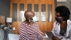 A woman chats with a clinician in her home A woman chats with a clinician in her home