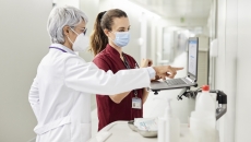 A doctor and a nurse using a laptop in a hospital. A doctor and a nurse using a laptop in a hospital.