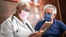 Doctor talking to senior male patient in a home visit Doctor talking to senior male patient in a home visit