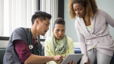 A provider showing a patient and their family member information on a tablet A provider showing a patient and their family member information on a tablet