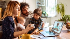 A family talking to a doctor on their laptop. A family talking to a doctor on their laptop.