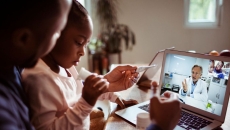 Adult and child talking to a provider through a video chat Adult and child talking to a provider through a video chat