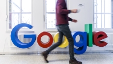 A person walking by the Google logo A person walking by the Google logo