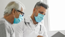 An older man and doctor looking at results on a tablet. An older man and doctor looking at results on a tablet.