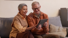 Two elderly persons using a tablet computer