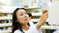 A pharmacist pulling a medication off a shelf. A pharmacist pulling a medication off a shelf.