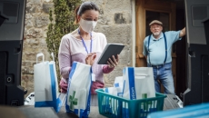 A man waiting in a doorway as a woman delivers medications A man waiting in a doorway as a woman delivers medications