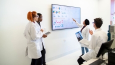 A group of researchers looking at data on a television screen. A group of researchers looking at data on a television screen.