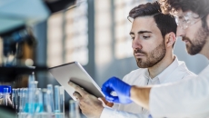 Two scientists in a lab looking at a tablet Two scientists in a lab looking at a tablet