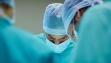 A close up of surgeons working in an operating room. A close up of surgeons working in an operating room.