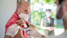 An older man getting a vaccine. An older man getting a vaccine.