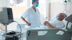 Healthcare provider standing next to a patient in a hospital bed