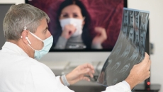 A doctor looking at a patient's x-ray while in a video consultation
