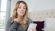 A person talking on a video chat on a phone about a sore throat A person talking on a video chat on a phone about a sore throat