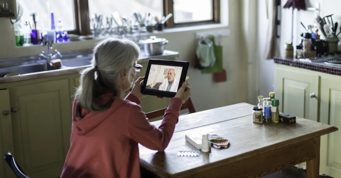 
  An older person talking to a provider through a video chat on a tablet.
