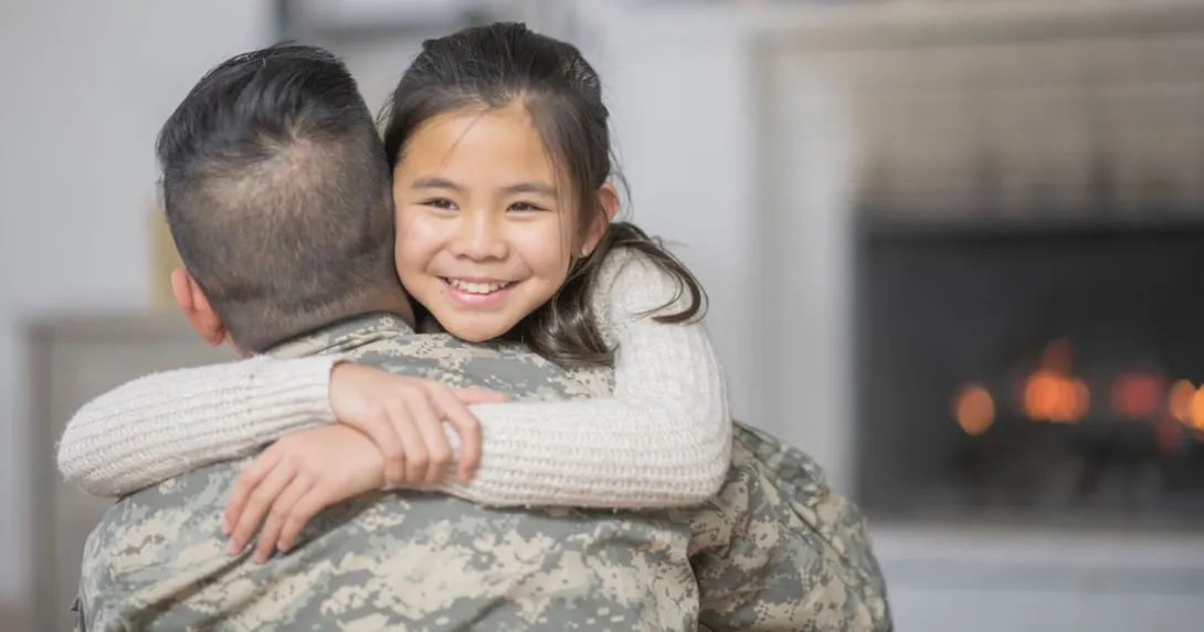 Soldier in uniform with his back turned while hugging someone not in uniform