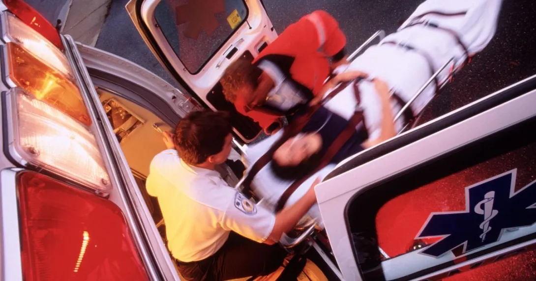 Responders move a patient on a stretcher inside the ambulance Responders move a patient on a stretcher inside the ambulance