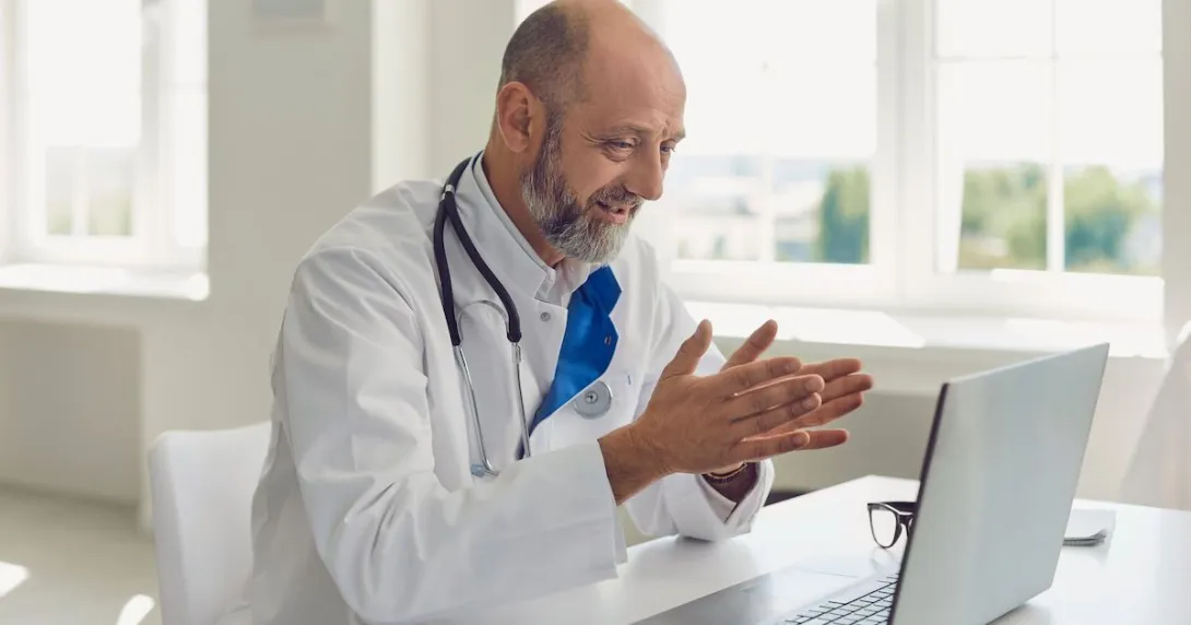 Doctor sitting at a desk looking at a computer