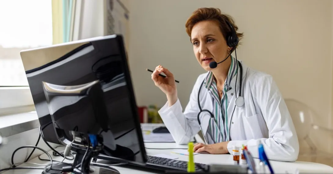 A doctor uses headphones with a mic in a call A doctor uses headphones with a mic in a call